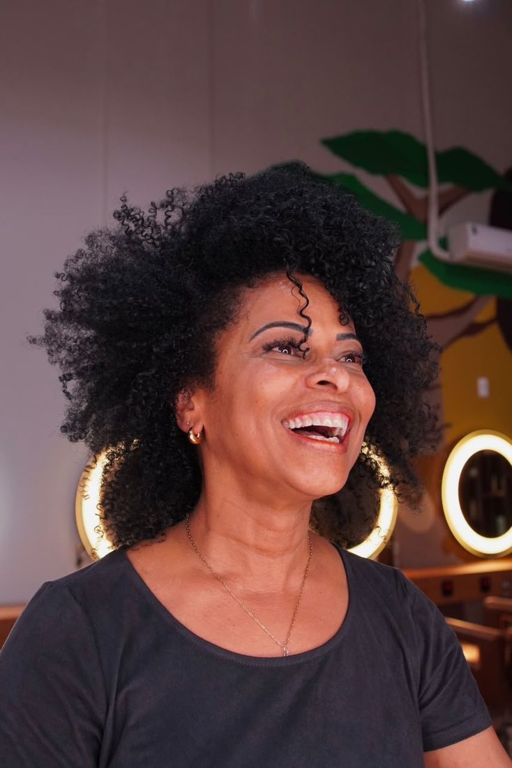 Cliente sorrindo com crespo natural preto e volumoso